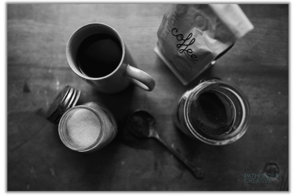 Coffee cup and sugar and coffee beans on a wooden table