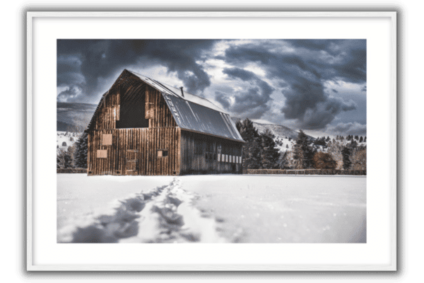 wood barn in the snow with storm clouds above