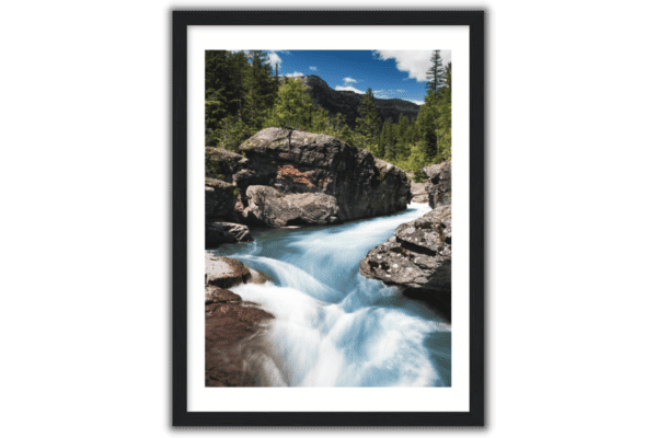 black frame around poster print of glacier national park blue creek with green trees and blue sky