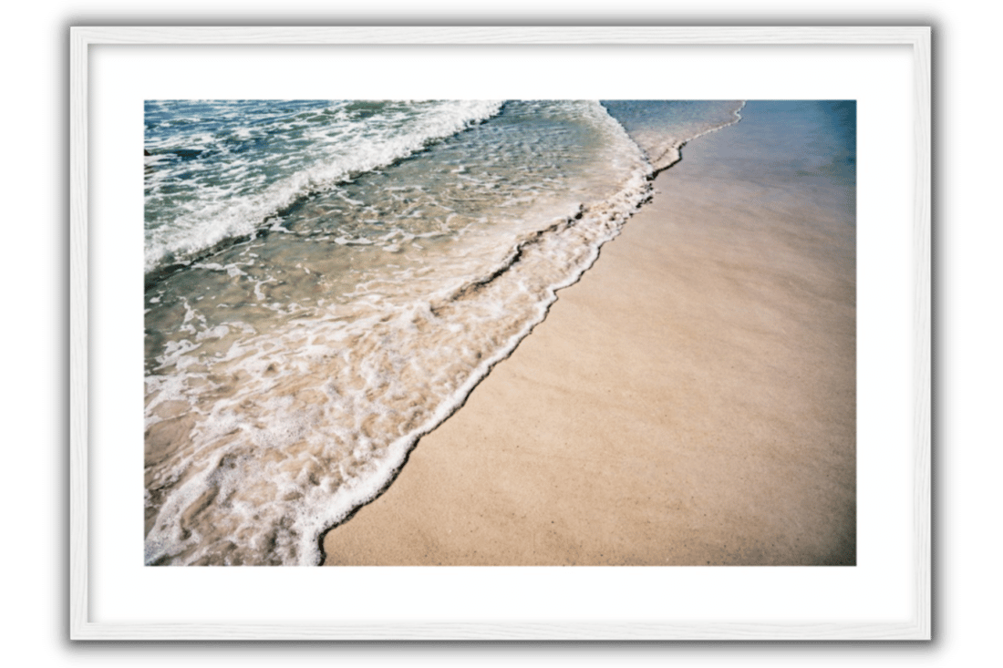 blue and green ocean waves and the sandy beige beach