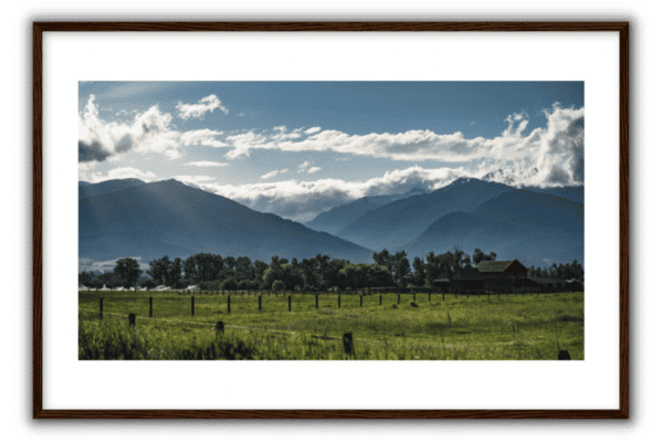 summer in the valley with mountains, green fields, white clouds, blue skies