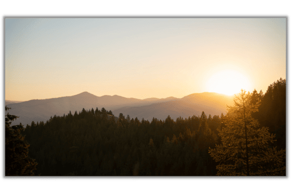 canvas print of forested mountains and an orange sunrise over the mountains