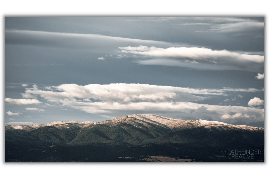 beautiful green mountains with snow capped peaks, blue sky, white clouds