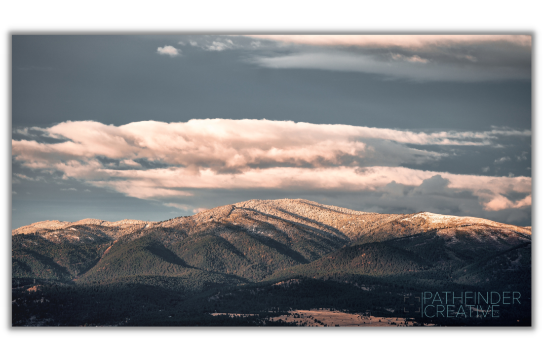 early morning mountain landscape with clouds and fresh snow on mountains