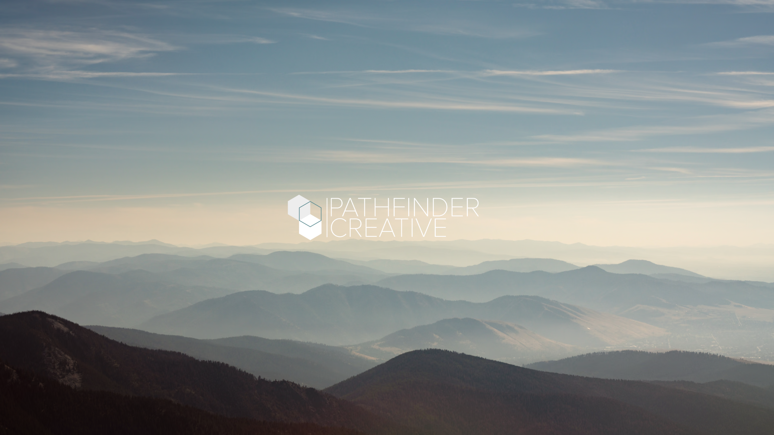 mountains with haze and pathfinder creative marketing logo.
